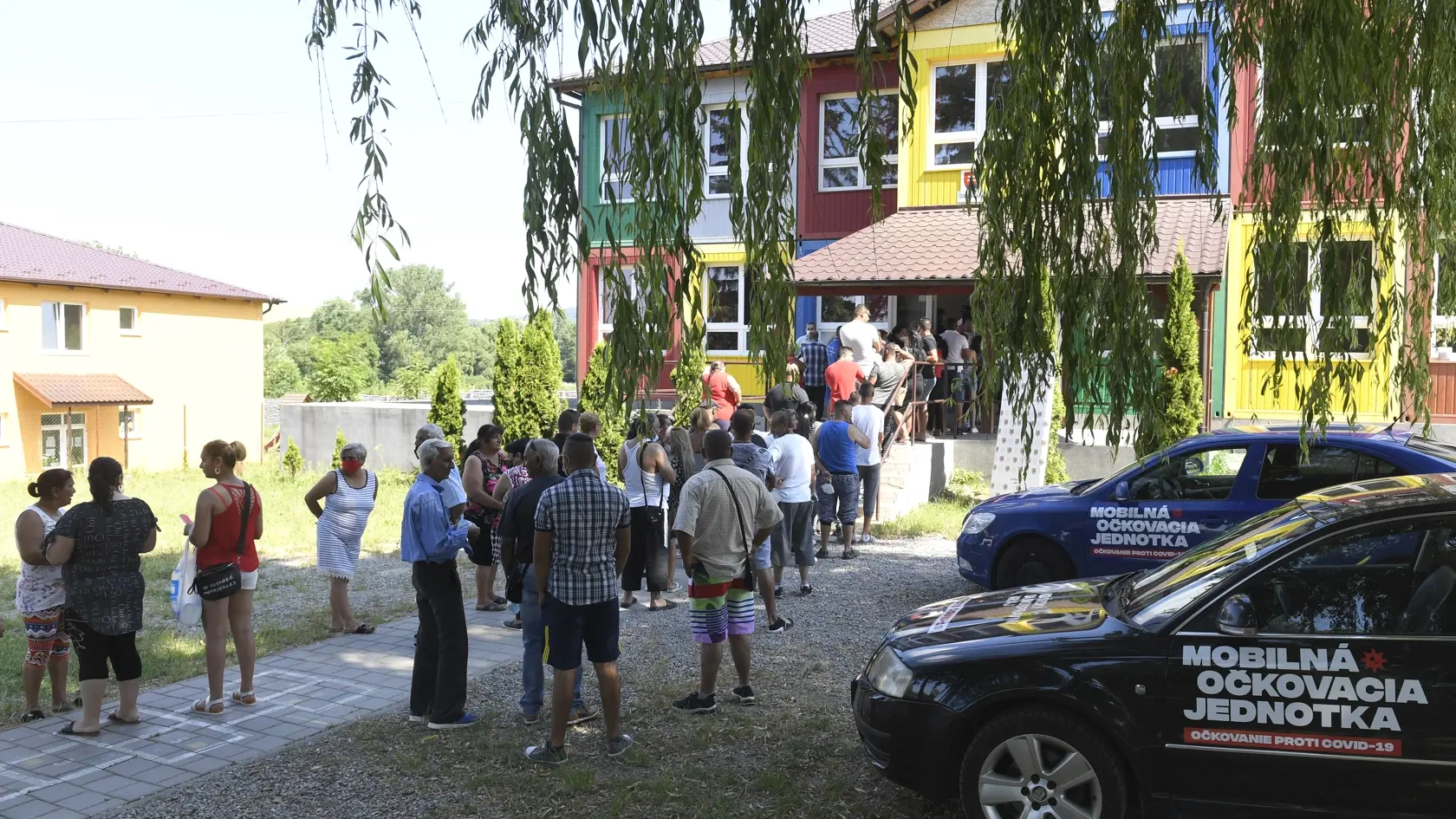 Začiatok očkovania ľudí z marginalizovaných komunít v Košickom samosprávnom kraji. Na snímke Rómovia z osady v obci Kecerovce, v okrese Košice-okolie čakajú v rade na očkovanie pred základnou školou v pondelok 28. júna 2021. FOTO TASR – František Iván