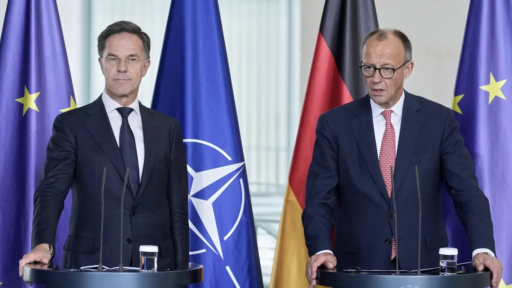 Generálny tajomník NATO Mark Rutte (vľavo) a nemecký kancelár Friedrich Merz diskutujú počas tlačovej konferencie.
