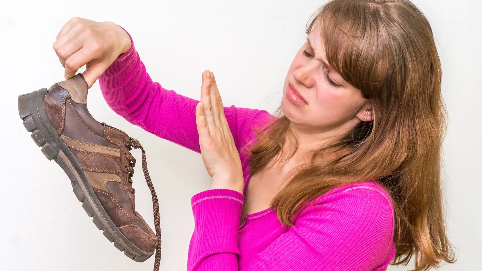 Woman holding dirty stinky shoes