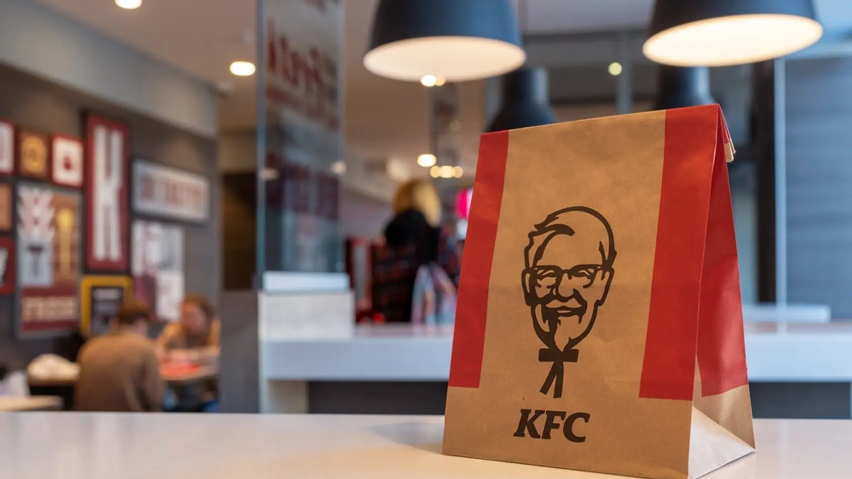 KFC paper bag with Kentucky Fried Chicken on the table of a KFC restaurant. Minsk, Belarus - March 8, 2024