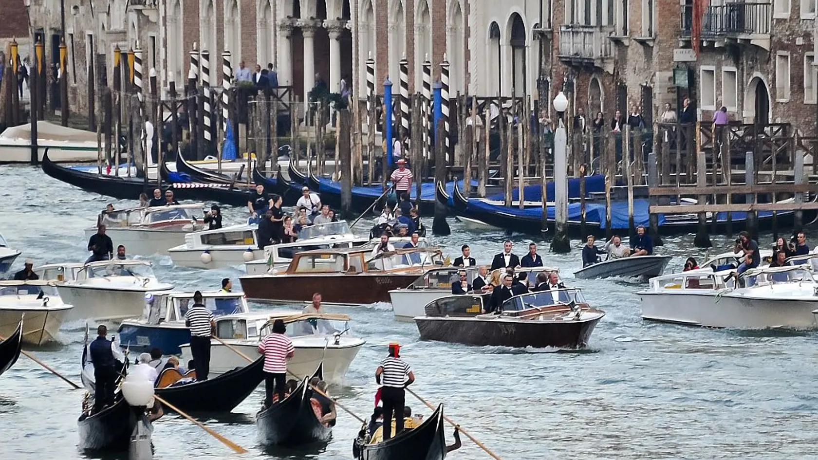The boat carrying actor George Clooney and his guests cruises in front of media boats in the Grand Canal on its way to the Aman hotel ahead of his wedding in Venice, Italy, Saturday, Sept. 27, 2014. (AP Photo/Luigi Costantini)