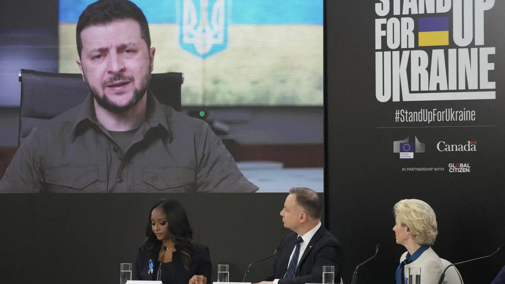 WA 71 Varšava -  Predsedníčka Európskej komisie (EK) Ursula von der Leyenová (vpravo) a poľský prezident Andrzej Duda (druhý sprava) počúvajú ukrajinského prezidenta Volodymyra Zelenského, ktorý sa pripojil prostredníctvom telemostu na podujatie s názvom 'Postavme sa za Ukrajinu vo Varšave v sobotu 9. apríla 2022. V rámci celosvetovej zbierky pre ukrajinských vojnových utečencov s názvom "Postavme sa za Ukrajinu" sa vyzbieralo 10,1 miliardy eur. Oznámila to v sobotu vo Varšave šéfka Európskej ko