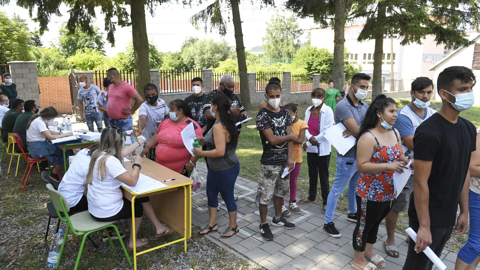 Na snímke ľudia stoja v rade na očkovanie proti ochoreniu COVID-19 v rámci pilotného projektu mobilného očkovania v teréne pod záštitou Ministerstva školstva, vedy, výskumu a športu (MŠVVŠ) SR v priestoroch základnej školy v obci Kecerovce, v okrese Košice-okolie v pondelok  12. júla 2021. Ministerstvo robí maximum pre to, aby školy mohli ostať otvorené celý budúci školský rok.  FOTO TASR – František Iván