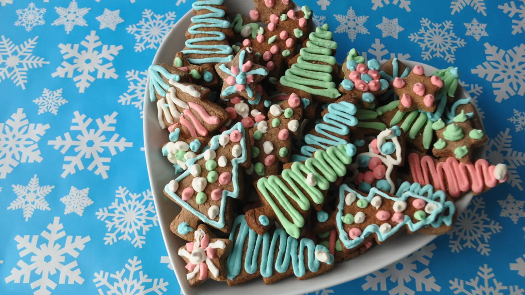 Decorated Christmas honey cookies medovniky from Slovakia, on winter background with snowflakes 