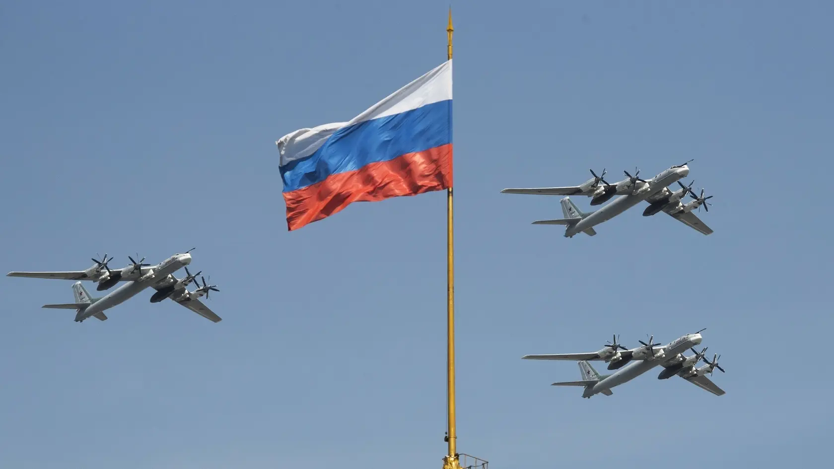 Na archívnej snímke zo 4. mája 2018 ruské strategické bombardéry Tu-95 prelietavajú okolo ruskej vlajky počas nácviku vojenskej prehliadky ku Dňu víťazstva v Moskve.