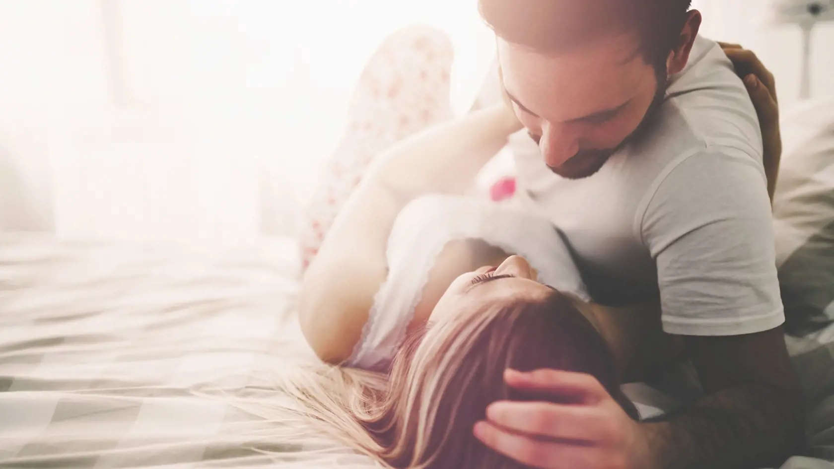 Sensual romantic foreplay by couple in love in bed