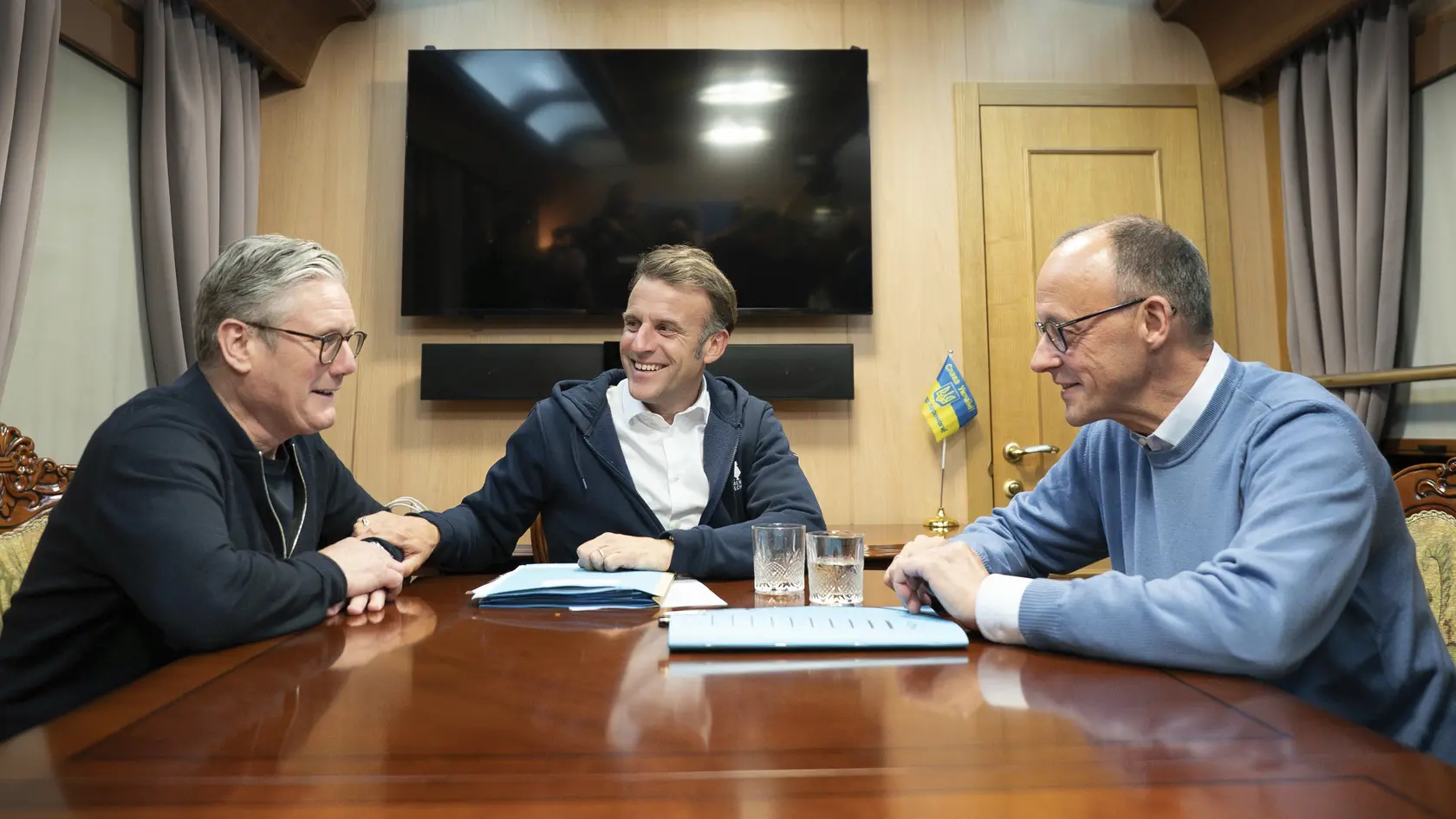 Britský premiér Keir Starmer (vľavo) rokuje s francúzskym prezidentom Emmanuelom Macronom (v strede) a nemeckým kancelárom Friedrichom Merzom vo vlaku na ceste do ukrajinského hlavného mesta Kyjev. Macron má v ľavej ruke schovanú hgienickú vreckovku.