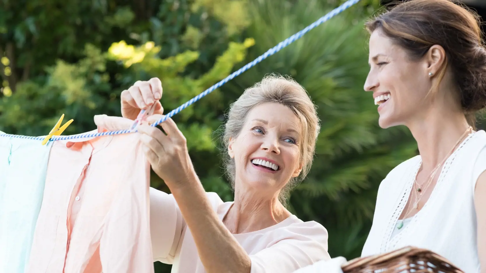 Older,Mother,And,Young,Daughter,Hanging,Clothes,Outdoor,To,Dry.