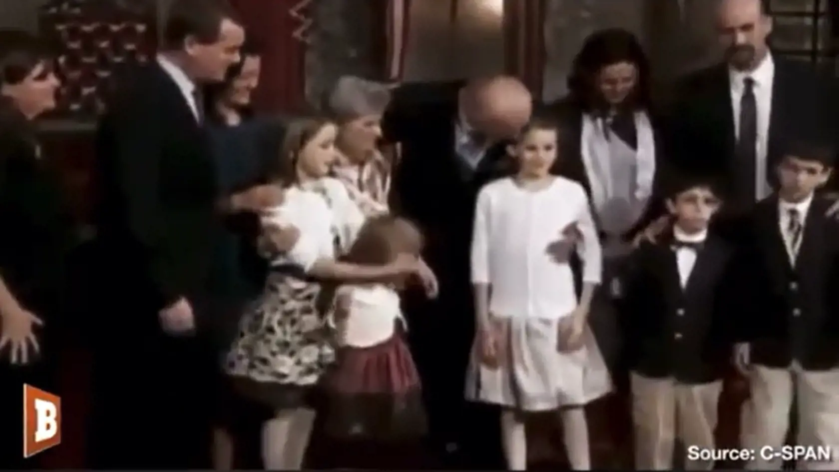 Joe Biden drží dievča tesne pod pazuchou.