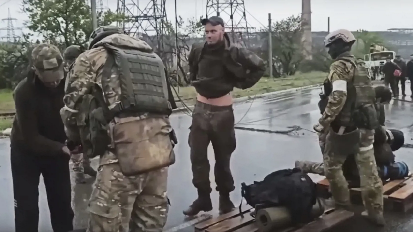 WA 29 Mariupol - Na videosnímke ruského ministerstva obrany vydanej vo štvrtok 19. mája 2022, ruskí vojaci (chrbtom) prehľadávajú ukrajinských vojakov (tvárou), ktorí opustili oceliarne Azovstaľ obliehané niekoľko týždňov ruskou armádou v juhoukrajinskom prístavnom meste Mariupol. FOTO TASR/AP 

 
In this photo taken from video released by the Russian Defense Ministry on Thursday, May 19, 2022, shows Russian servicemen frisking Ukrainian servicemen after they leaved the besieged Azovstal steel p