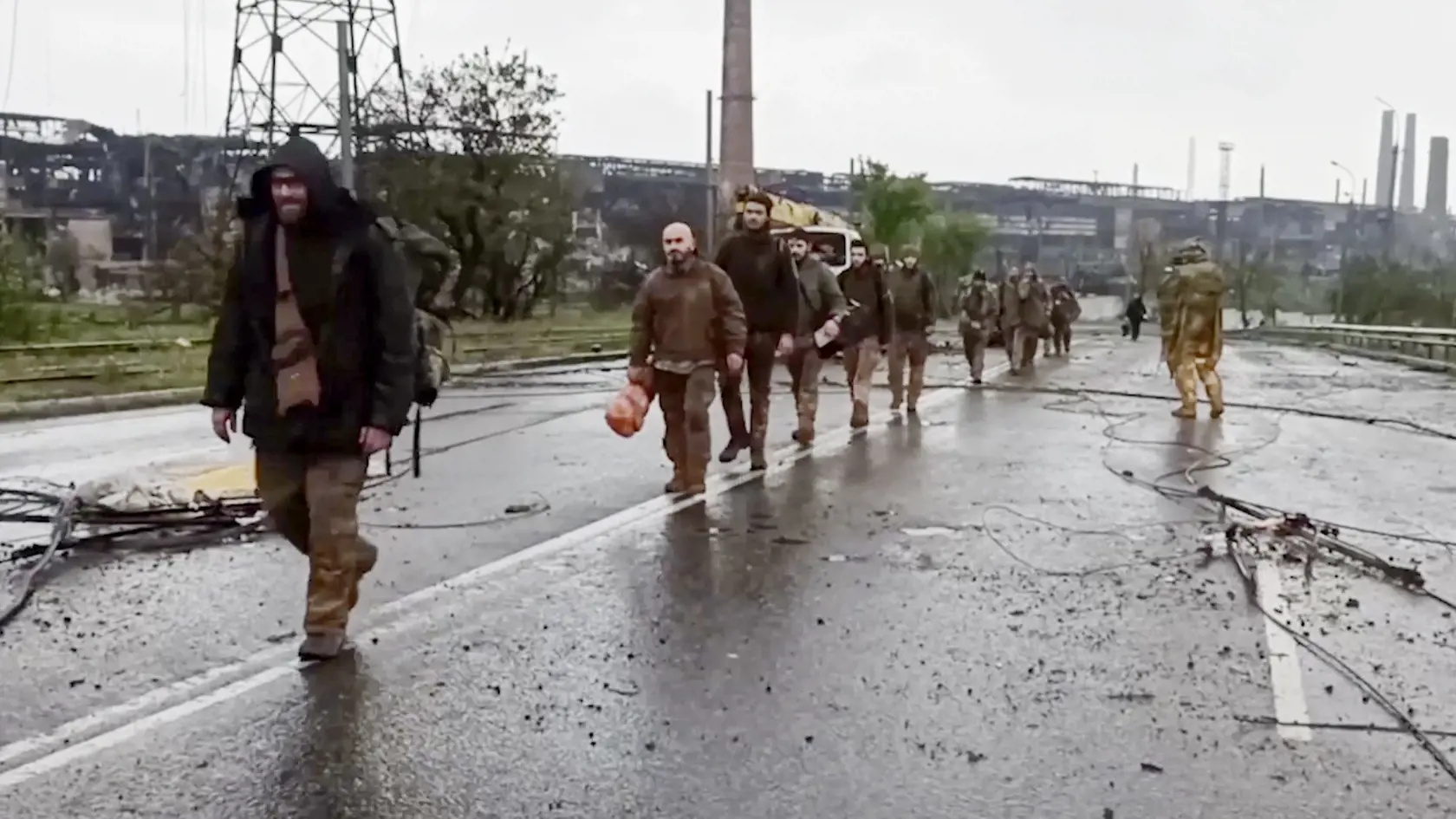 WA 23 Mariupol - Na videosnímke ruského ministerstva obrany vydanej vo štvrtok 19. mája 2022, ukrajinskí vojaci, ktorí niekoľko týždňov odolávali útokom ruských síl v oceliarniach Azovstaľ, kráčajú po ceste pred závodom ocelarní v juhoukrajinskom prístavnom meste Mariupol. FOTO TASR/AP 

 
Ukrainian servicemen sit in a bus traveling from Mariupol to a prison in Olyonivka after they leave the besieged Mariupol's Azovstal steel plant, in Mariupol, in territory under the government of the Donetsk P