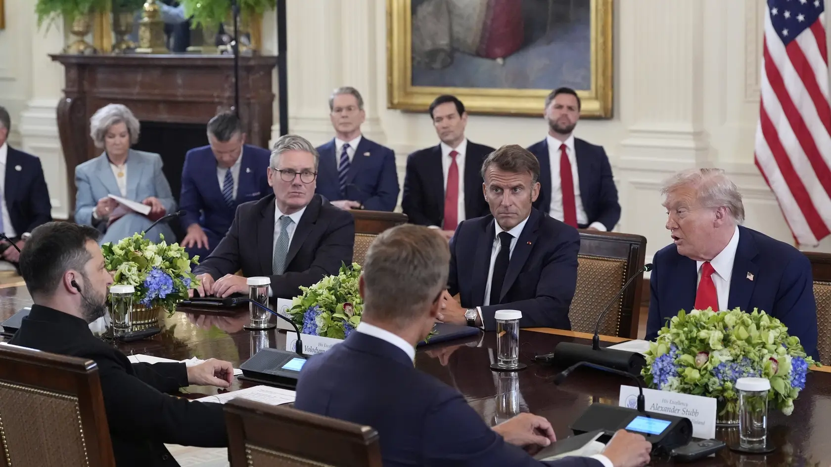 KK77 Washington - Za stolom v pozadí zľava britský premiér Keir Starmer, francúzsky prezident Emmanuel Macron, americký prezident Donald Trump, v popredí za stolom zľava ukrajinský prezident Volodymyr Zelenskyj, fínsky prezident Alexander Stubb a v pozadí sprava americký viceprezidet J. D. Vance, americký minister zahraničných vecí Marco Rubio, americký minister financií Scott Bessent, americký minister obrany Pete Hegseth a šéfka prezidentskej kancelárie Susie Wilesová počas stretnutia v Bielom dome vo Washingtone v pondelok 18. augusta 2025. Americký prezident Donald Trump v pondelok večer stredoeurópskeho letného času privítal v Bielom dome svojho ukrajinského partnera Volodymyra Zelenského. Po spoločnom rokovaní sa americký prezident stretol aj s lídrami európskych krajín. Rokovať budú o prímerí vo vojne na Ukrajine a summite na Aljaške, na ktorom sa Trump zišiel s ruským prezidentom Vladimirom Putinom. FOTO TASR/AP
President Donald Trump, seated at the table from center right, speaks as France's President Emmanuel Macron, British Prime Minister Keir Starmer, Finland's President Alexander Stubb, foreground right, Ukrainian President Volodymyr Zelenskyy, foreground left, and from background right, Vice President JD Vance, Secretary of State Marco Rubio, Treasury Secretary Scott Bessent, Defense Secretary Pete Hegseth and White House Chief of Staff Susie Wiles listen during a meeting with European leaders in the East Room of the White House, Monday, Aug. 18, 2025, in Washington. (AP Photo/Alex Brandon)