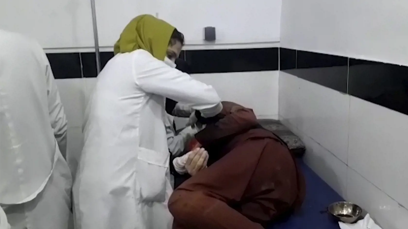 KK52 Kábul - Na videosnímke zdravotníčka ošetruje osobu neďaleko zranenú počas výbuchu pri letisku v Kábule 26. augusta 2021. Pri bombových útokoch pri letisku Hámida Karzaja v afganskej metropole Kábul zahynulo najmenej 60 afganských civilistov a 150 utrpelo zranenia, píše denník The Wall Street Journal (WSJ) s odvolaním sa na vysoko postaveného afganského zdravotníckeho predstaviteľa. Ministerstvo obrany USA (Pentagón) v tejto súvislosti potvrdilo, že výbuchy si vyžiadali aj životy amerických 