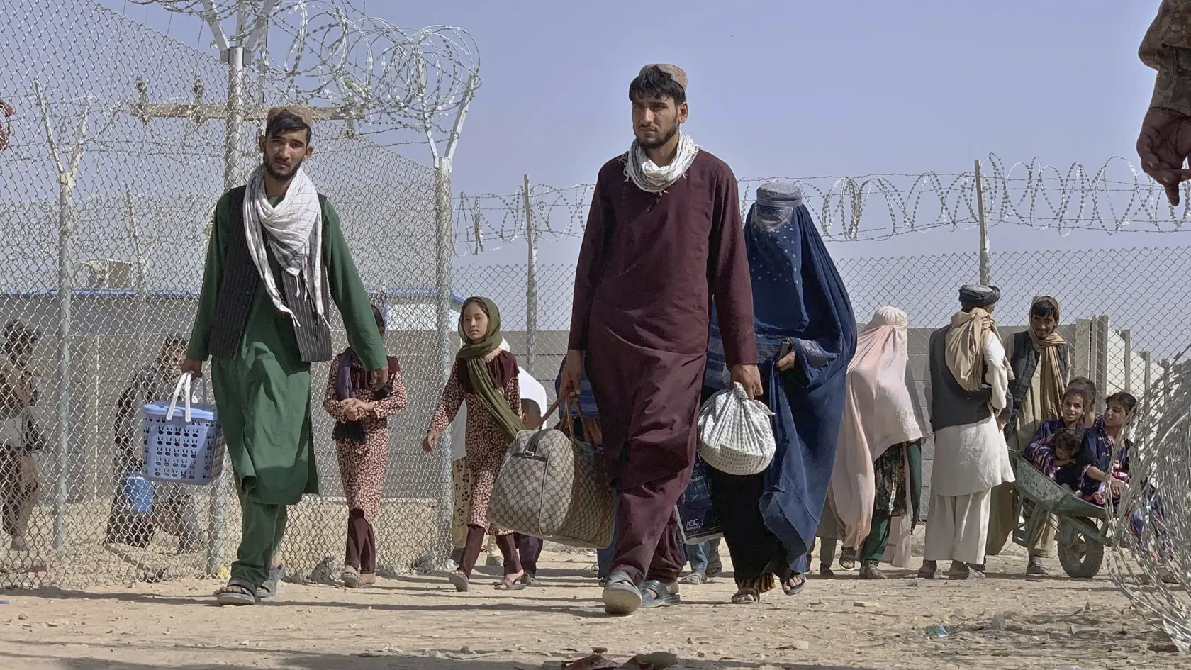 JB 21 Čaman - Afganci, ktorí opustili svoje domovy, kráčajú cez bezpečnostnú bariéru po tom, ako prekročili hranicu do Pakistanu v blízkosti hraničného priechodu medzi Pakistanom a Afganistanom, ktorý pred niekoľkými dňami zatvorili, v pakistanskom meste Čaman 26. augusta 2021. FOTO TASR/AP