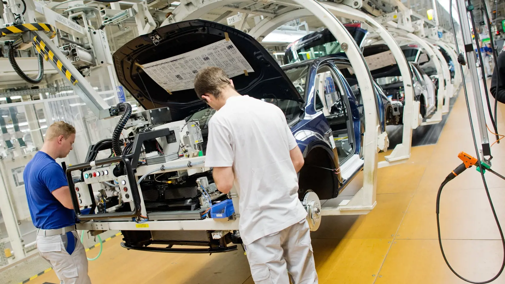 WA 24 Wolfsburg - Zamestnanci pracujú na montážnej linke v závode automobilky Volkswagen v nemeckom meste Wolfsburg, 21. októbra 2015.