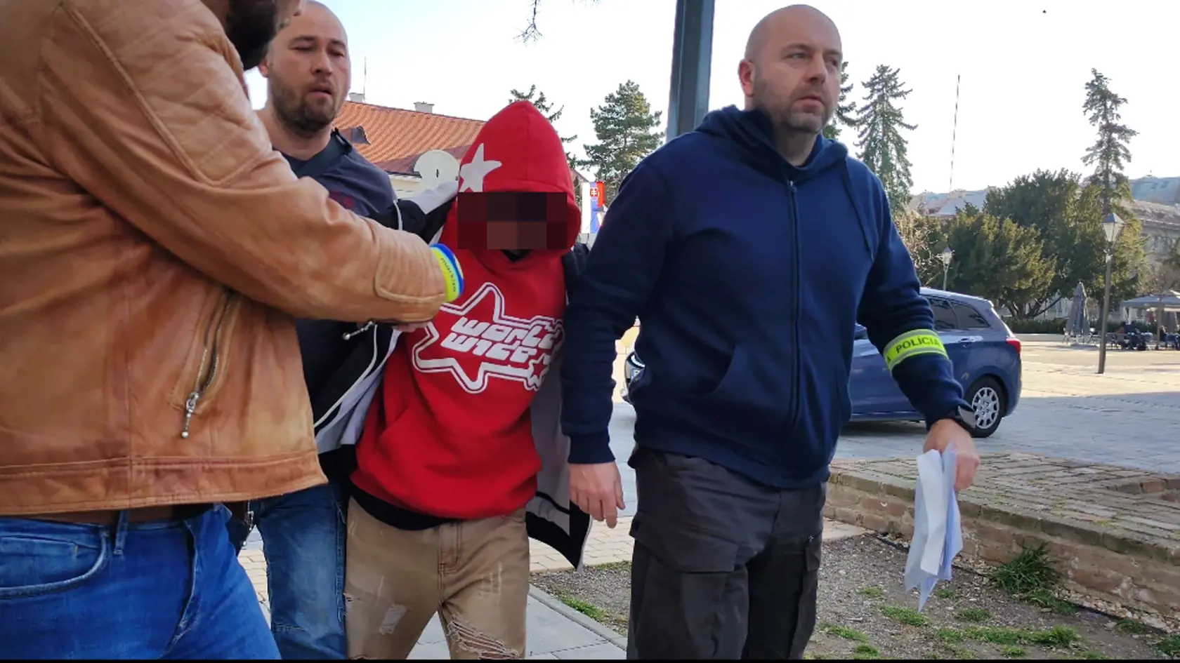 Policajná eskorta privádza na súd v Trnave 15-ročného mladíka, ktorý mal v Piešťanoch dobiť 18-ročného Tomáša teleskopickou palicou.