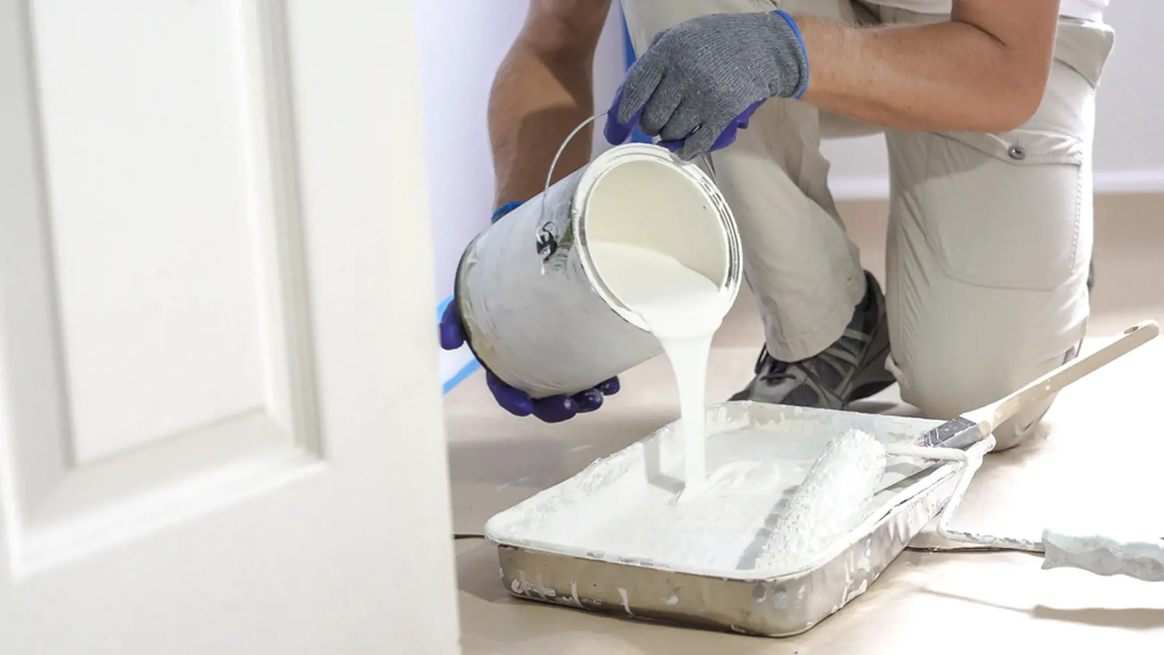 Man,Pours,Paint,Into,The,Tray,And,Dips,Roller.,Professional