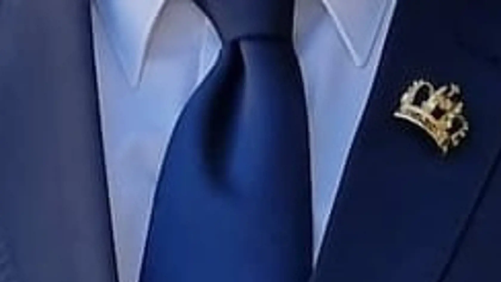 Výrazným detailom na klope saka bola luxusná zlatá kráľovská korunka vykladaná drahými kameňmi.