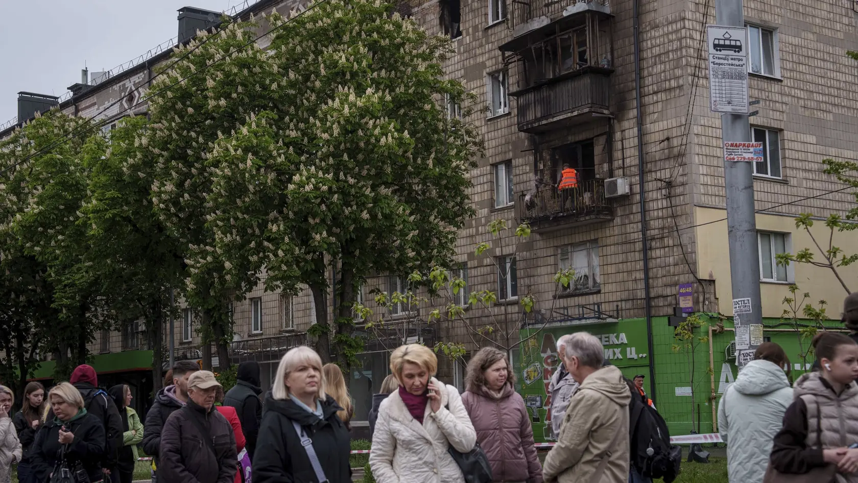Miestni obyvatelia čakajú na električku pred bytovkou, ktorú zasiahol ruský nočný útok v ukrajinskej metropole Kyjev v stredu 7. mája 2025.