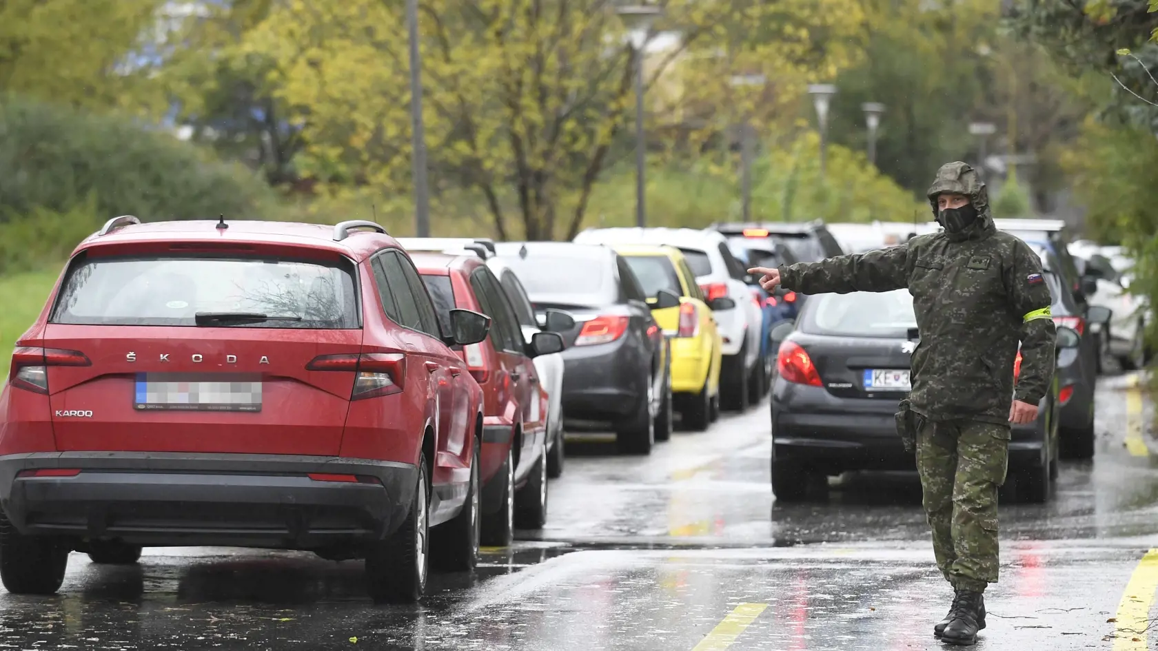 Pri veľkokapacitnom odberovom mieste na Ipeľskej ulici v Košiciach  vypomáhajú dvaja príslušníci ozbrojených síl SR, ktorí usmerňujú dopravu a dohliadajú na plynulosť testovania. Košice, 13. októbra 2020. FOTO TASR - František Iván