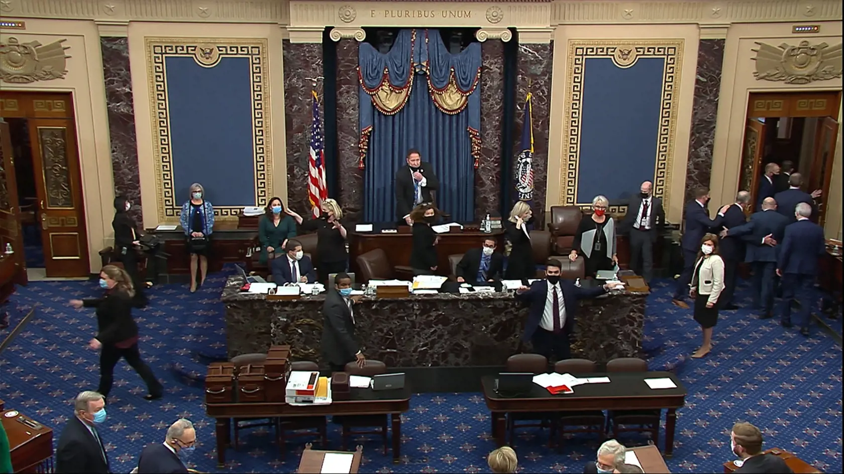 KK14 Washington - Na videosnímke evakuácia v sále Senátu po vniknutí demonštrantov do sídla amerického Kongresu vo Washingtone 6. januára 2021. Sídlo amerického Kongresu v hlavnom meste Washington v stredu uzavreli počas zasadnutia členov oboch jeho komôr po tom, ako sa stúpenci prezidenta Donalda Trumpa dostali do zrážok s políciou a pokúsili vniknúť do budovy. Senát i Snemovňa reprezentantov oznámili prerušenie svojho zasadnutia, zameraného na potvrdenie výsledkov prezidentských volieb. FOTO T