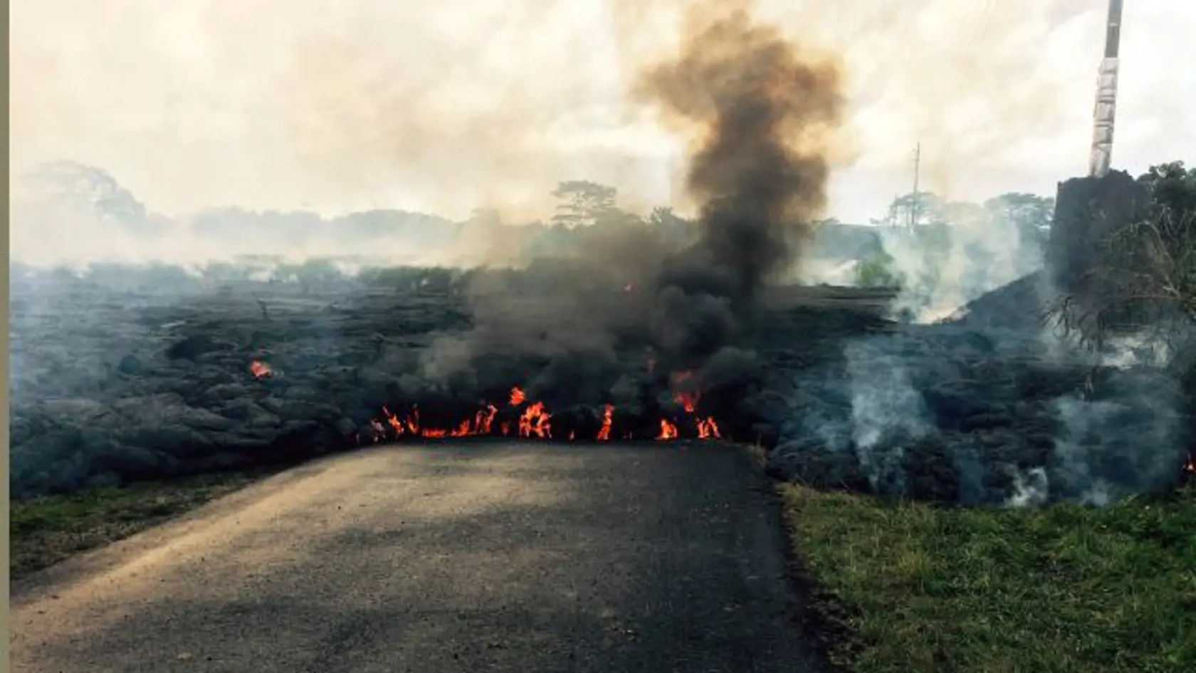 In this Oct. 24, 2014 photo from the U.S. Geological Survey, the lava flow from Kilauea Volcano that began June 27 is seen as it crossed Apa?a Street near Cemetery Road near the town of Pahoa on the Big Island of Hawaii.  Hawaii authorities on Saturday told several dozen residents near the active lava flow to prepare for a possible evacuation in the next three to five days as molten rock oozed across the country road and edged closer to homes. The USGS says the flow is currently about 160 to 230