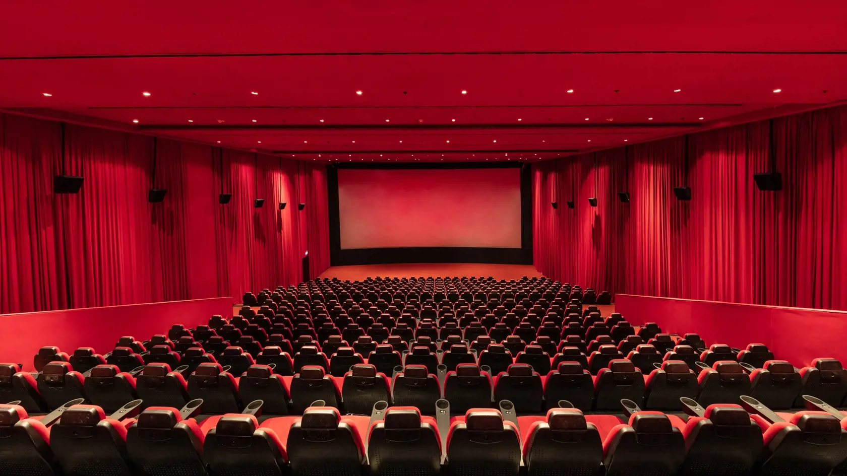 Empty red cinema hall seats, chairs. Perspective view