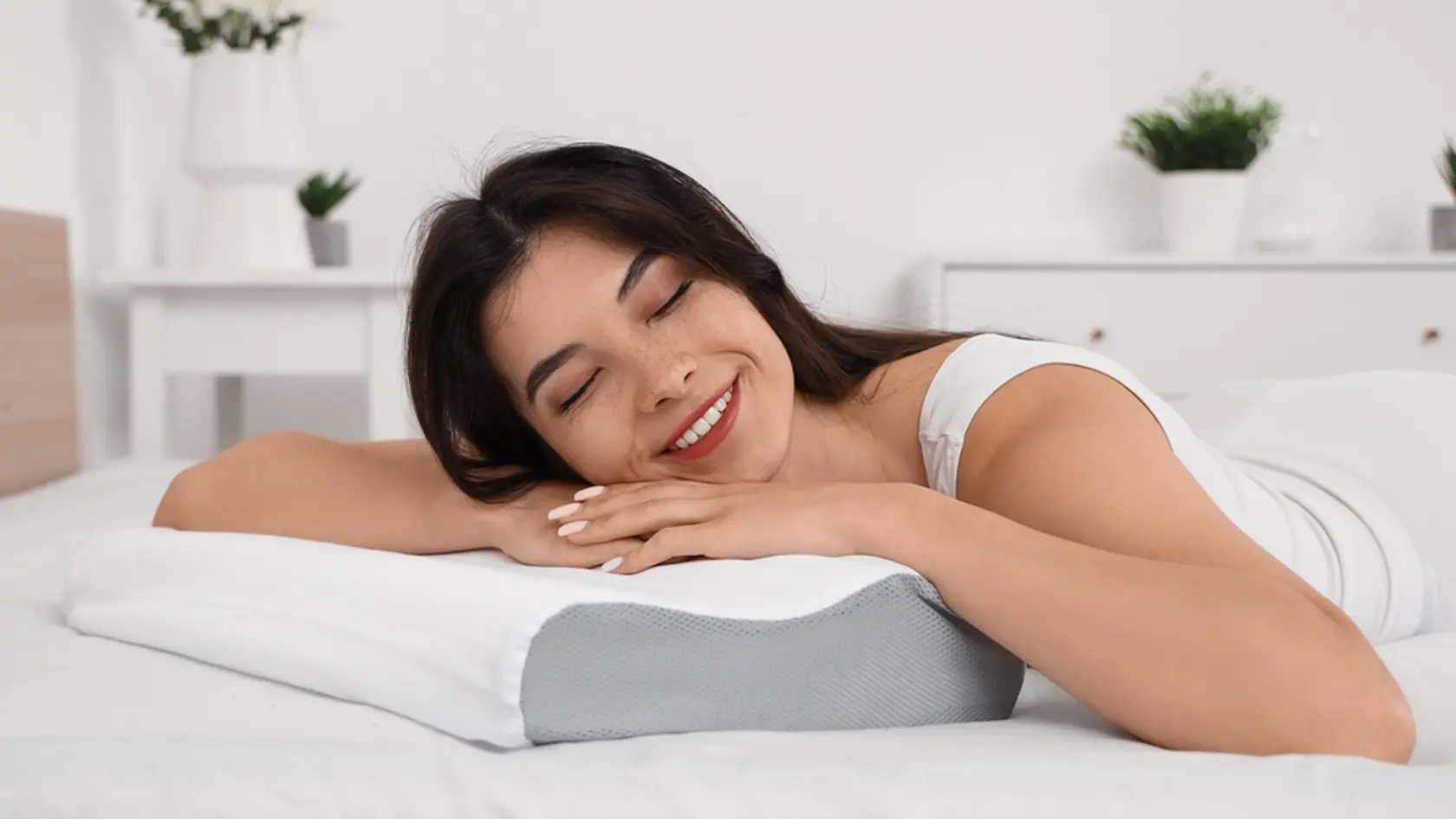 Young woman in pajamas sleeping on cozy orthopedic pillow at home
