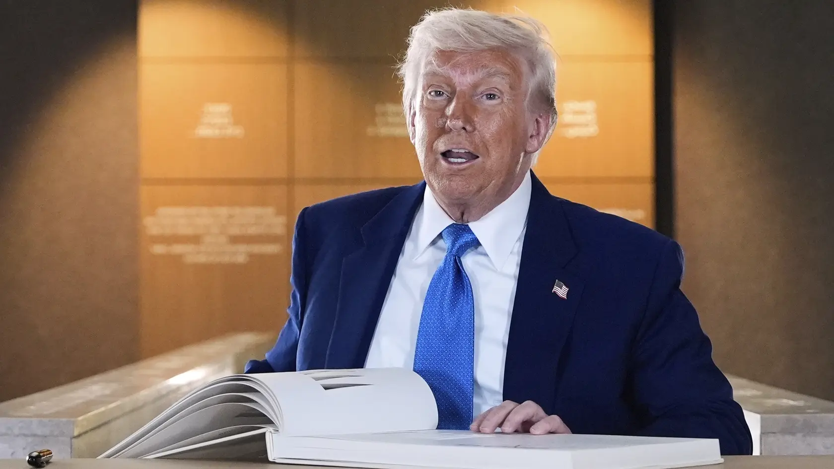 Americký prezident Donald Trump sa zapisuje do knihy hostí po jeho prehliadke v Dome Abrahámovej rodiny v Abú Zabí v piatok 16. mája 2025
