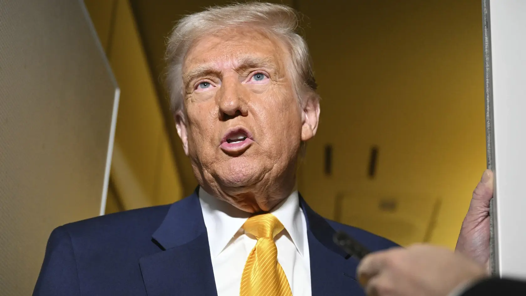 Na snímke prezident USA Donald Trump odpovedá na otázky reportérov počas letu do Miami 12. apríla 2025.