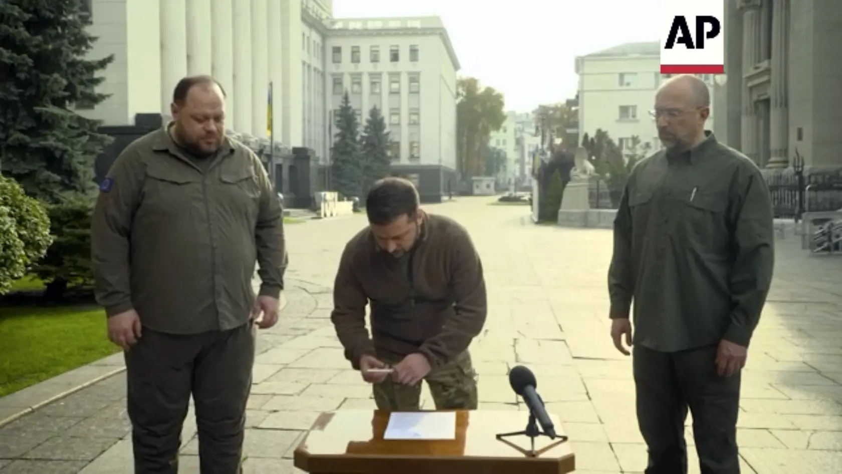 JB 35 Kyjev - Ma snímke z videa ukrajinský prezident Volodymyr Zelenskyj (uprostred) podpisuje prihlášku o zrýchlený vstup do NATO v Kyjeve 30. septembra 2022. Vpravo stojí ukrajinský premiér Denys Šmyhaľ a vľavo  predseda ukrajinského parlamentu (Najvyššej rady) Ruslan Stefančuk. Ukrajina podáva žiadosť o "zrýchlený" vstup do Severoatlantickej aliancie (NATO). V piatok to vyhlásil ukrajinský prezident Volodymyr Zelenskyj po tom, ako jeho ruský náprotivok Vladimir Putin podpísal zmluvy o pričlen