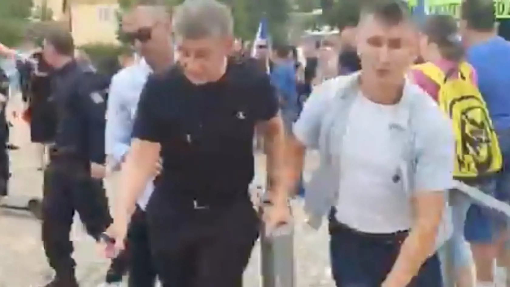 Andreja Babiša (v čiernom) vedú ochrankári do bezpečia.
