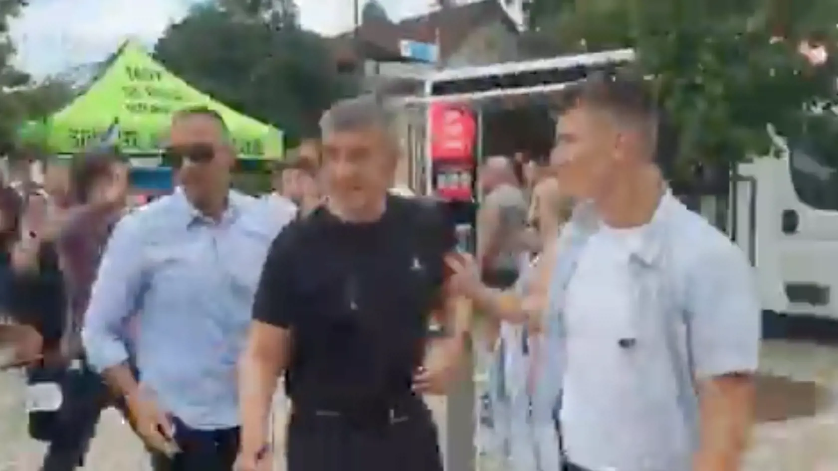 Andreja Babiša (v čiernom) vedú ochrankári do bezpečia.