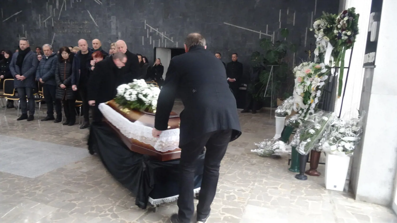 Zriadenci odvážajú truhlu k pohrebnému autu, ktoré ju malo odviesť na kremáciu do Košíc.