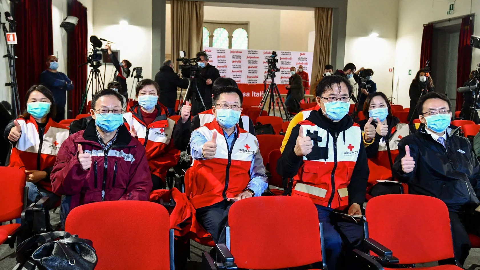 KK26 Rím - Doktori a členovia Čínskeho Červeného kríža pózujú pre spoločnú fotografiu pred tlačovou konferenciou v piatok 13. marca 2020 v Ríme. Tím zdravotníkov z Číny pricestoval vo štvrtok do Ríma, aby talianskym kolegom pomohol prekonať epidémiu koronavírusu. Ako v piatok informovala agentúra Sinchua, do Talianska pricestovali charterovým letom a spolu s 30 tonami zdravotníckeho materiálu a ochranných pomôcok. Doviezli napr. dýchacie prístroje, monitory a defibrilátory na zariadenie jednotky