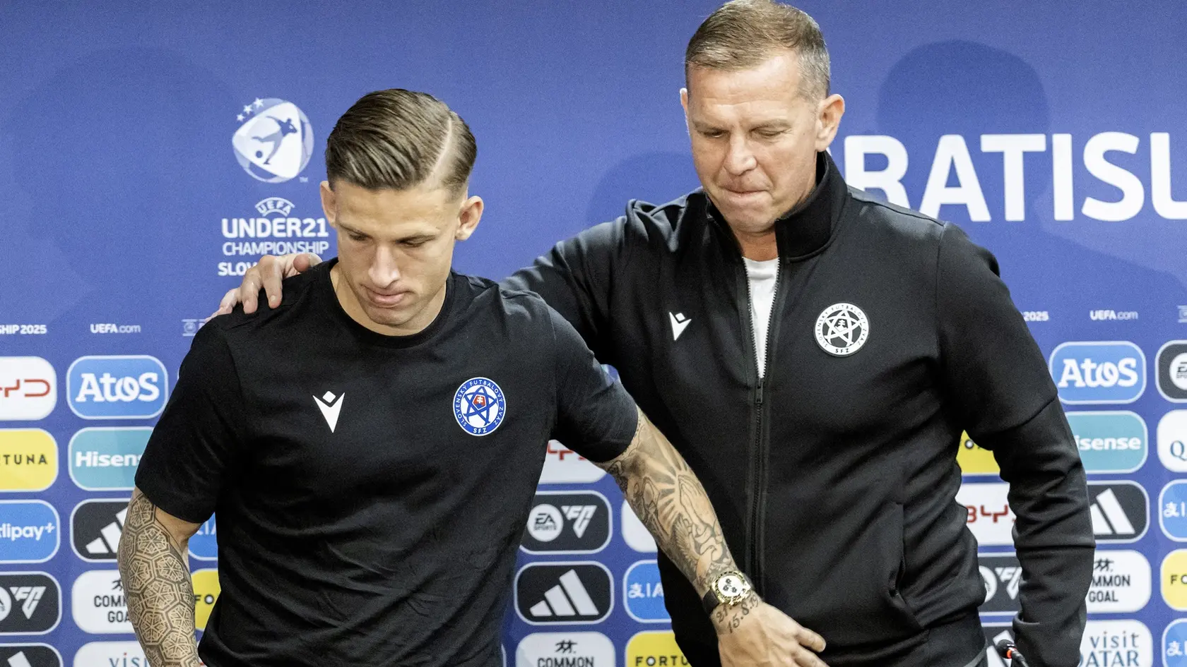 Na snímke sprava tréner slovenskej futbalovej reprezentácie do 21 rokov Jaroslav Kentoš a slovenský futbalista Tomáš Suslov reagujú po tlačovej konferencii pred záverečným zápasom A-skupiny  Rumunsko - Slovensko.