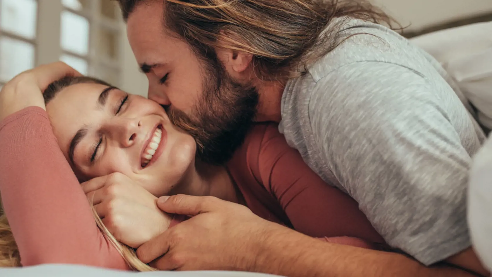 Couple,In,Bed,Spending,Time,Together,With,Man,Kissing,His