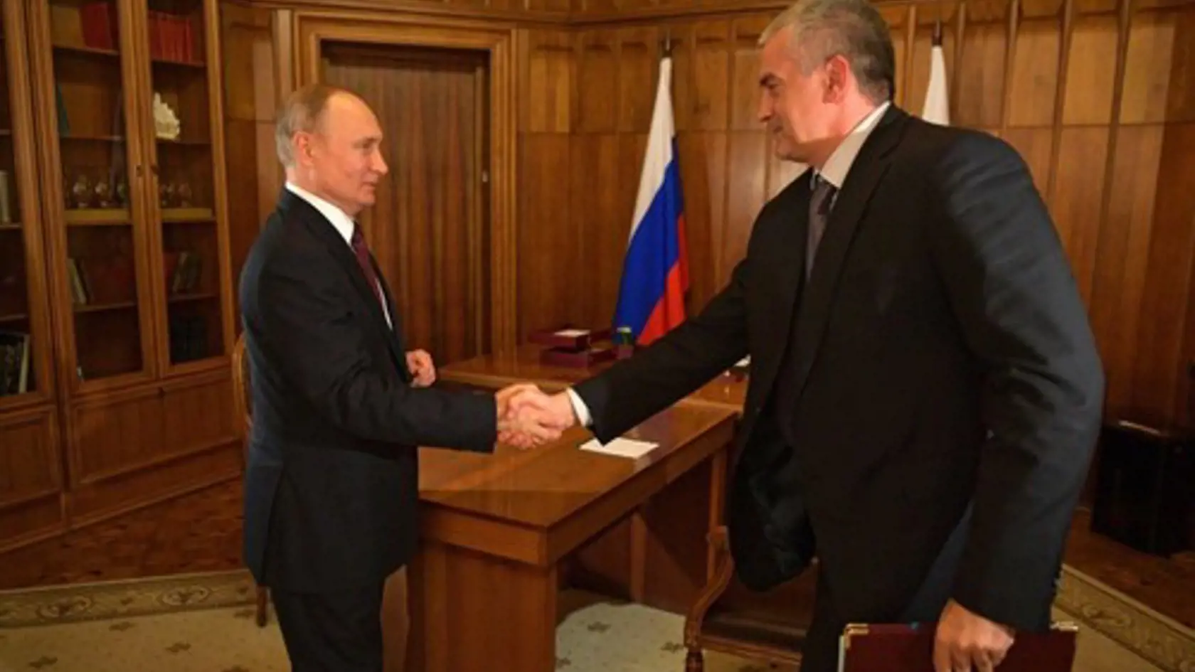 Ruský prezident Vladimir Putin (vľavo) a Sergej Aksyonov, šéf Krymskej republiky si trasú rukami.