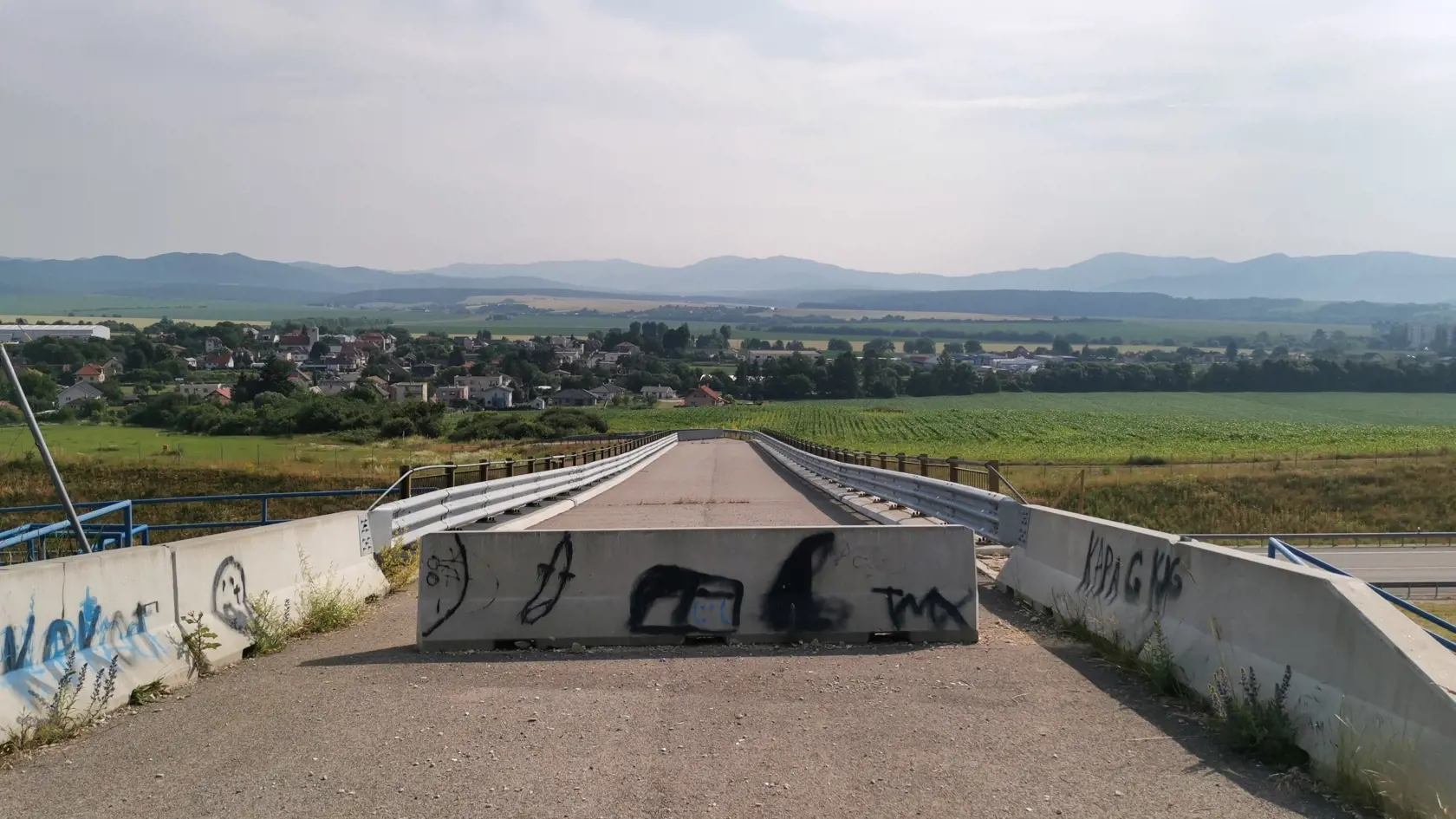 Na moste sú z oboch strán zátarasy a asfalt tu končí a ďalej cesta nepokračuje.