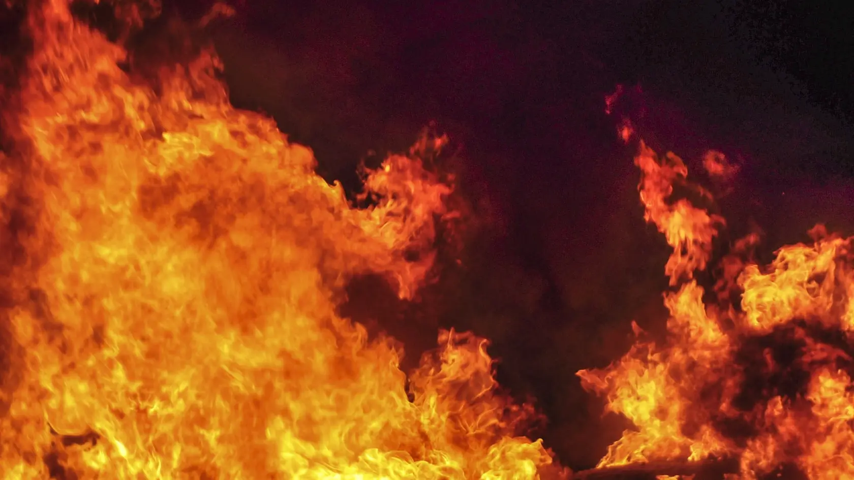 Shot of a roadside care fire at night.