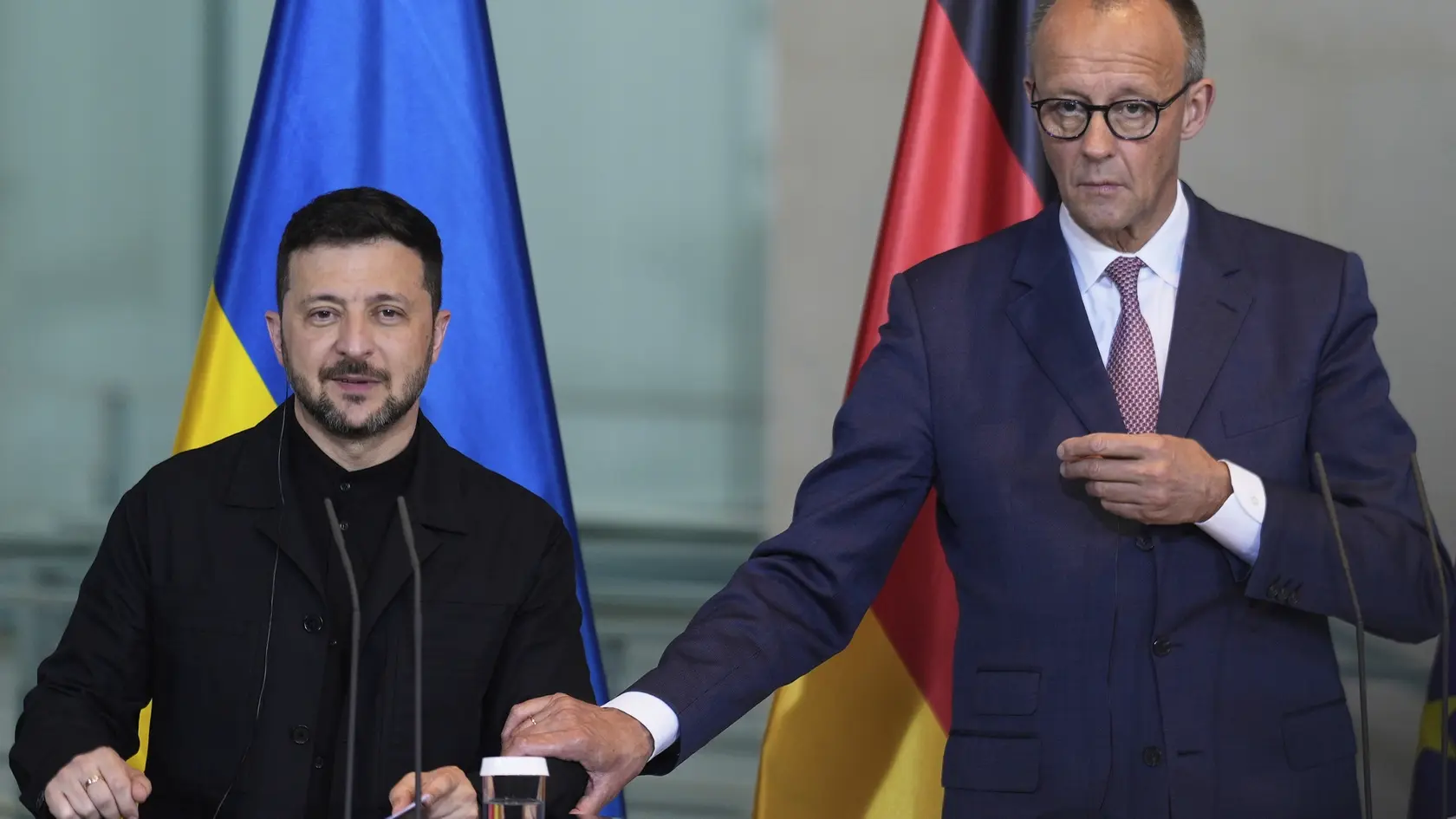 WA 28 Berlín - Ukrajinský prezident Volodymyr Zelenskyj (vľavo) a nemecký kancelár Friedrich Merz sa usmievajú počas spoločnej tlačovej konferencie v Berlíne.