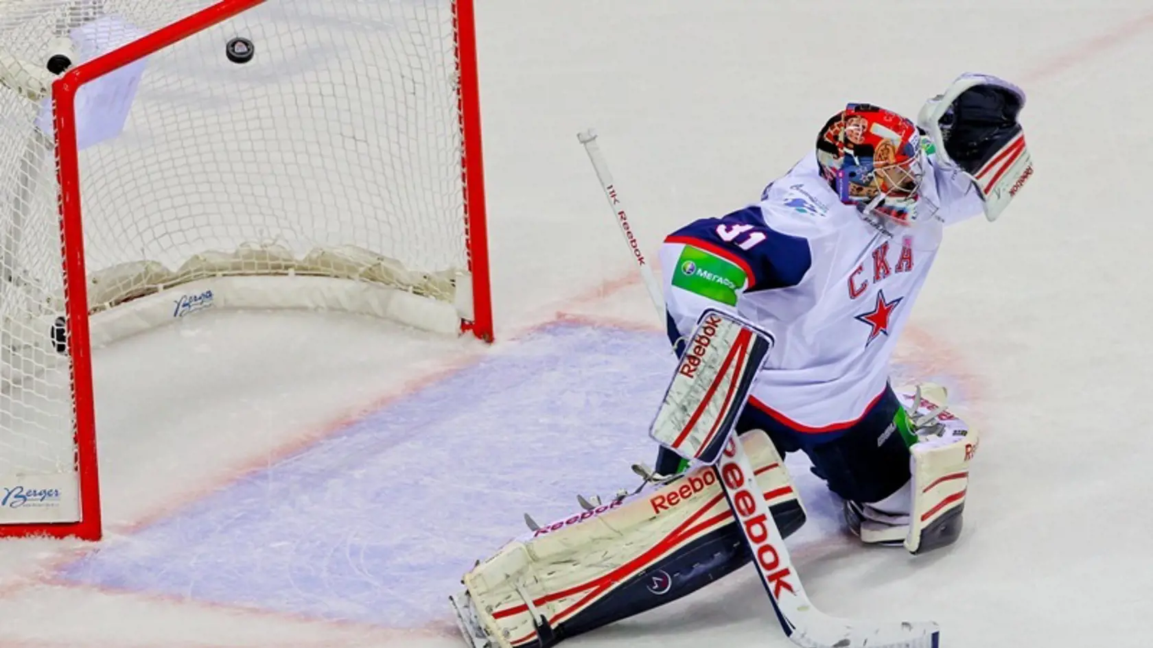 Jakub Štěpánek (SKA Petrohrad) inkasuje gól z hokejky Tomasa Mikusa (HC Slovan).