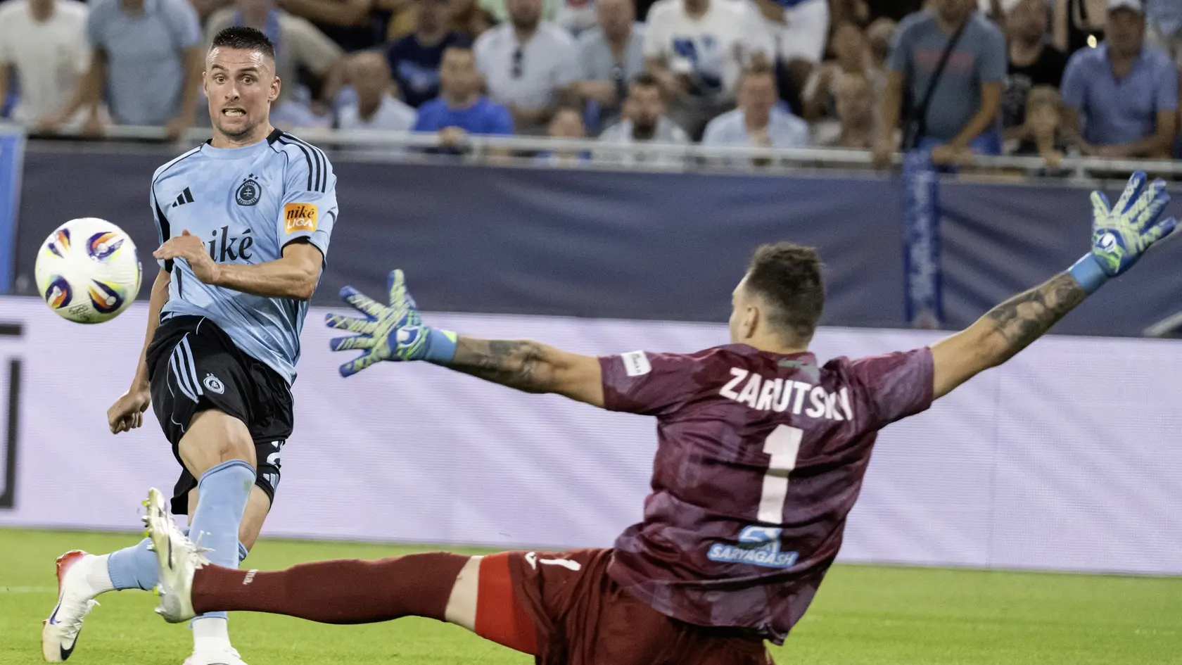 Na snímke zľava Róbert Mak (Slovan) v gólovej šanci, vpravo brankár Aleksandr Zaruckij (Almaty).