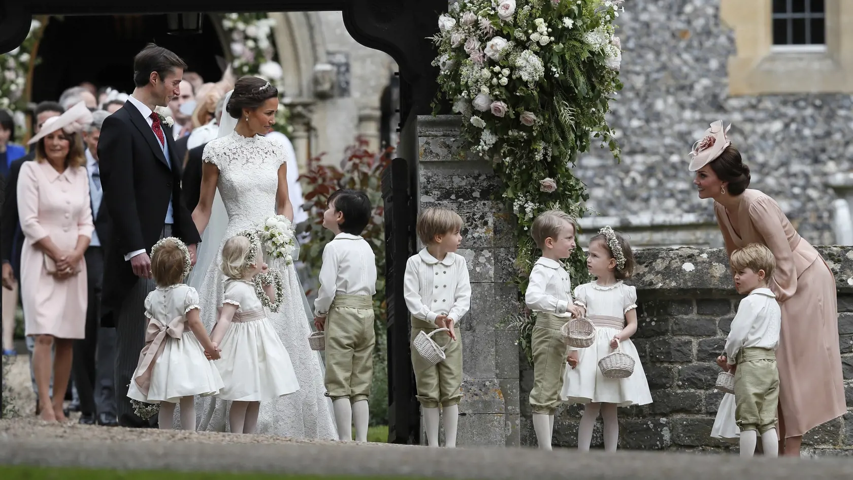 Kate, Duchess of Cambridge, right, stands with her son Prince George as she looks across at Pippa Middleton and James Matthews after their wedding at St Mark's Church in Englefield, England Saturday, May 20, 2017. Middleton, the sister of Kate, Duchess of Cambridge married hedge fund manager James Matthews in a ceremony Saturday where her niece and nephew Prince George and Princess Charlotte was in the wedding party, along with sister Kate and princes Harry and William. (AP Photo/Kirsty Wigglesw