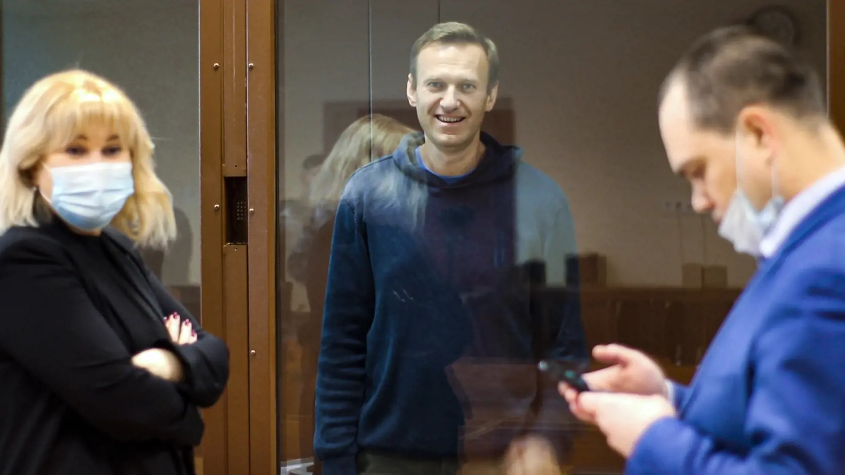 EBE 30 Moskva - Na snímke zverejnenej Babuškinským obvodným súdom sa vodca ruskej opozície Alexej Navaľnyj (uprostred) usmieva počas rozhovoru so svojimi právnikmi Olľou Michajlovovou (vľavo) a Vadimom Kobzevom (vpravo) počas pojednávania v Moskve v utorok 16. februára 2021. Na okresnom súde v Moskve sa začalo ďalšie pojednávanie v kauze ohovárania veterána druhej svetovej vojny, ktorého sa údajne dopustil opozičný politik a protikorupčný aktivista Alexej Navaľnyj. Podľa prokuratúry, ktorá na ut