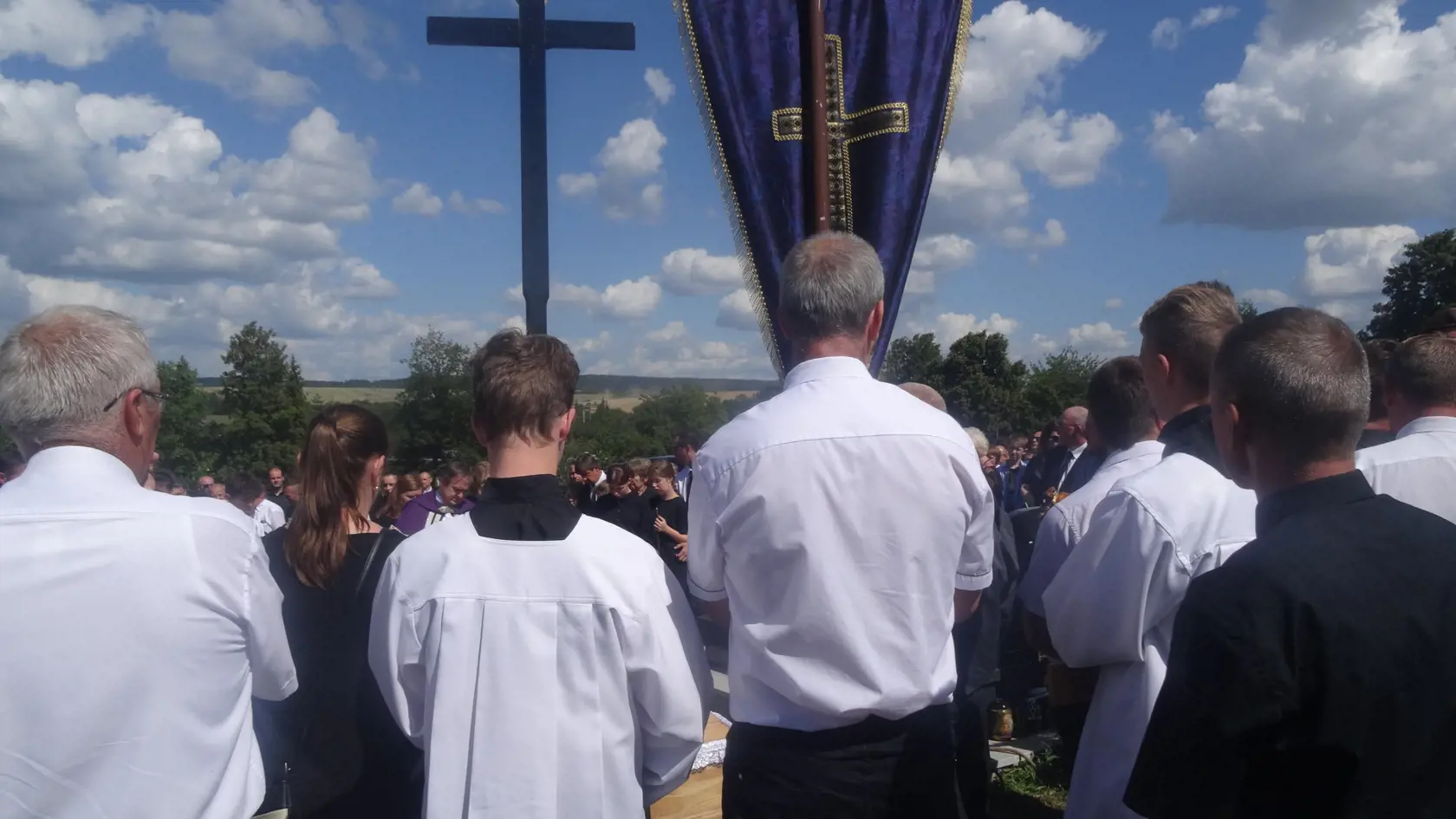 V čele smútočného sprievodu kráčal muž so zástavou a miništrant s krížom.