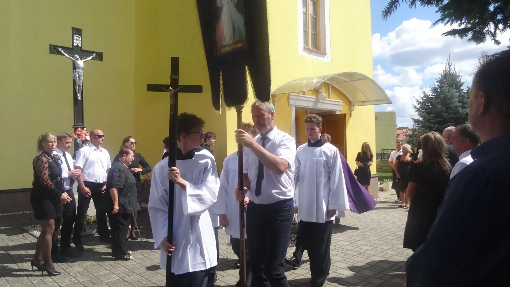 V čele smútočného sprievodu kráčal muž so zástavou a miništrant s krížom.