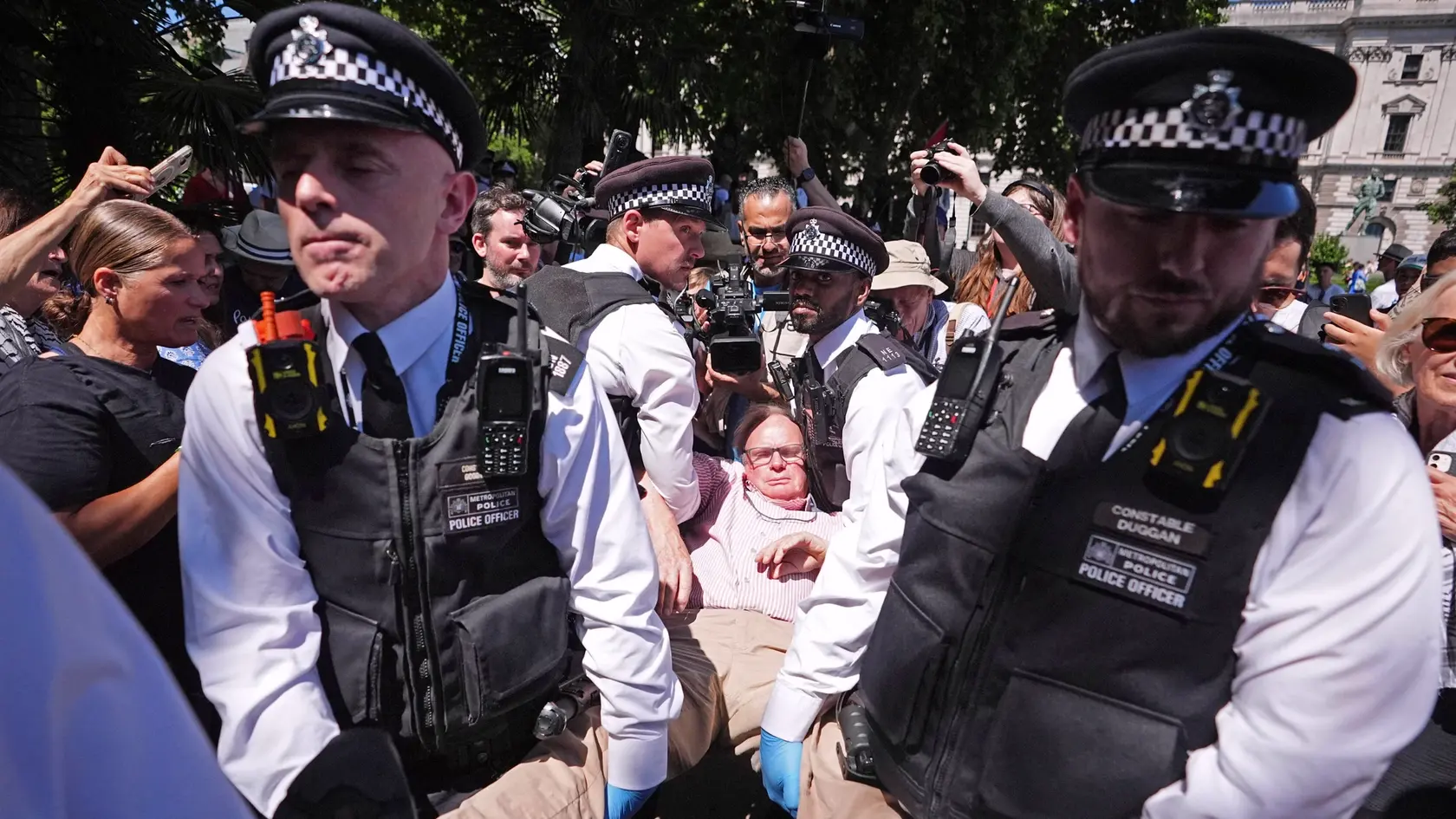 Policajti odvádzajú osobu po tom, ako sa zúčastnila na proteste na podporu zakázanej organizácie Palestine Action v Londýne.