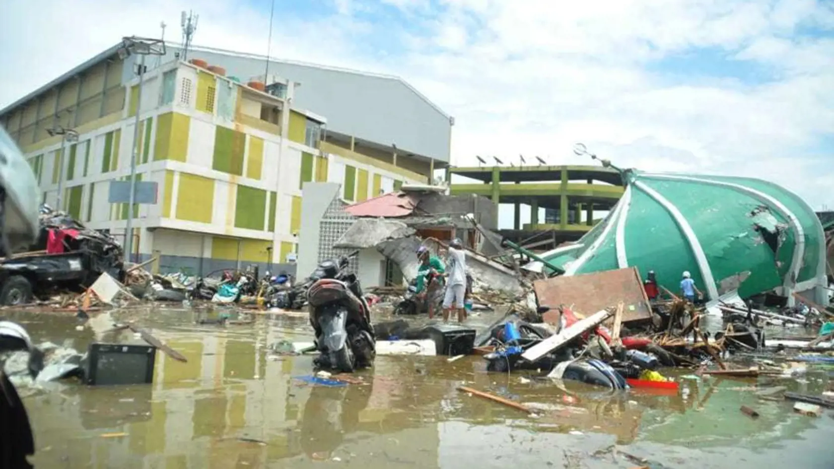 People survey the damage following a massive earthquake and tsunami in Palu, Central Sulawesi, Indonesia, Sunday, Sept. 30, 2018. Rescuers were scrambling Sunday to try to find trapped victims in collapsed buildings where voices could be heard screaming for help after a massive earthquake in Indonesia spawned a deadly tsunami two days ago. (AP Photo/Rifki)