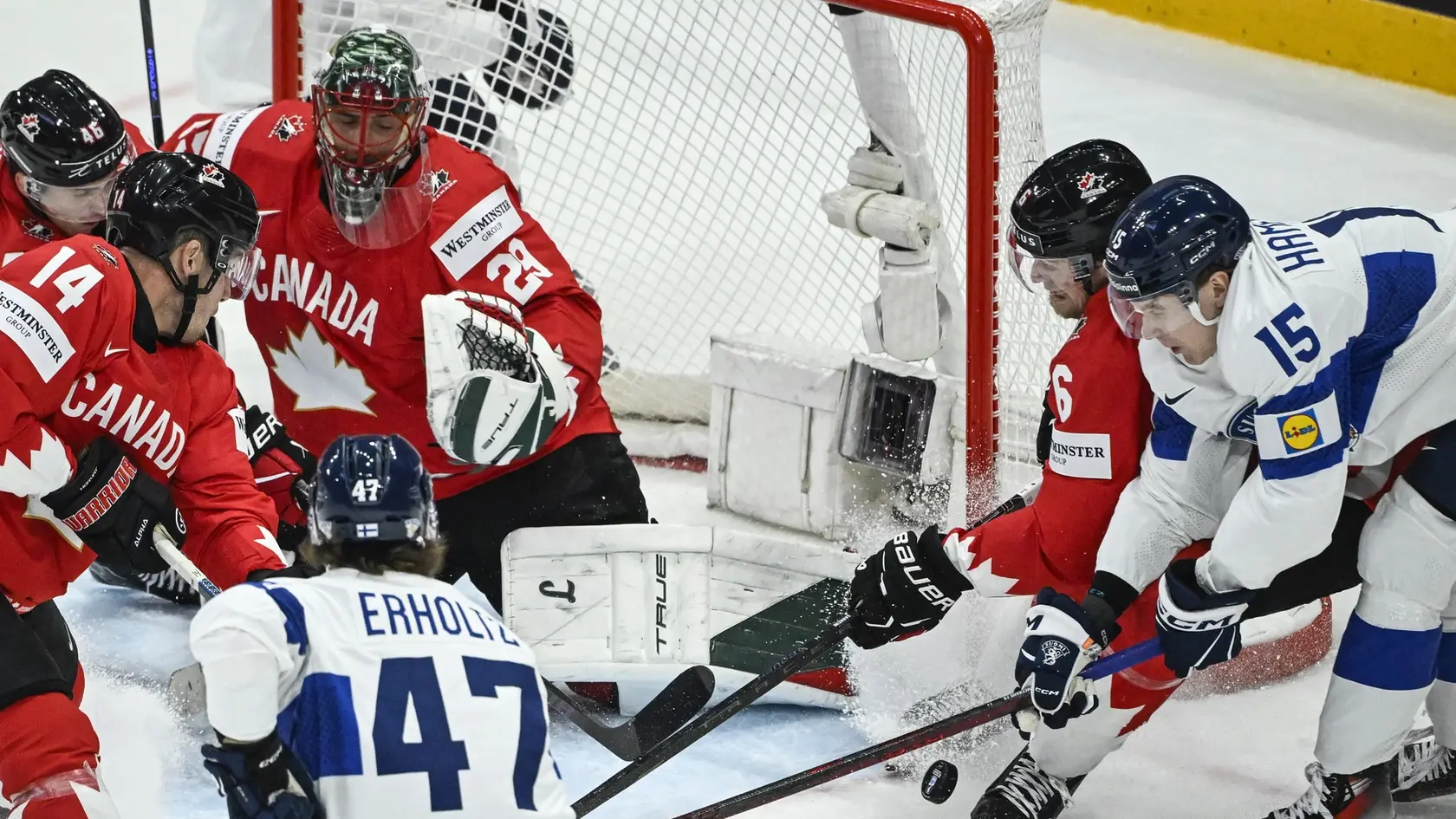 Kanadský brankár Marc-Andre Fleury (uprostred), hokejisti Fínska Lenni Hämeenaho (vpravo) a Eemil Erholtz (47) počas zápasu.